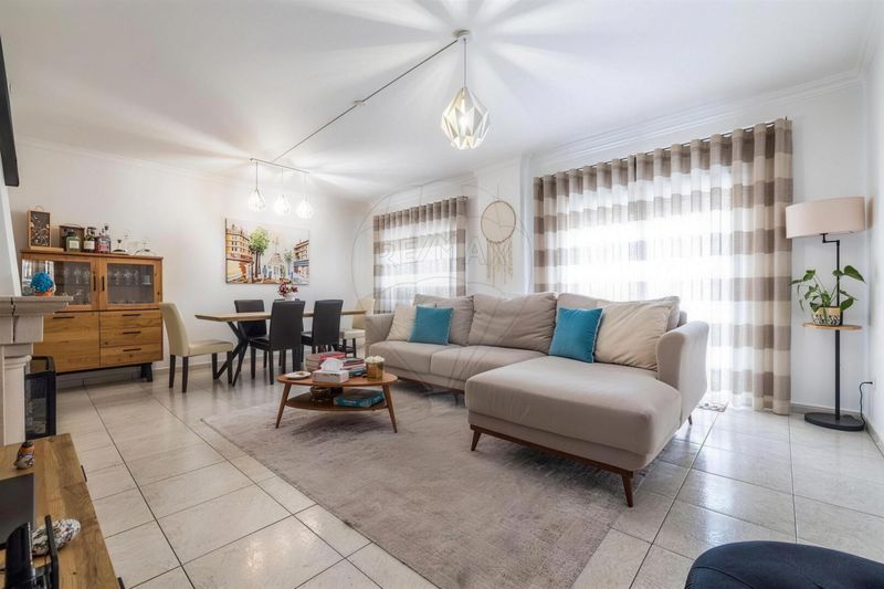 Sala comum ampla do apartamento T2, com sofá e zona de refeições